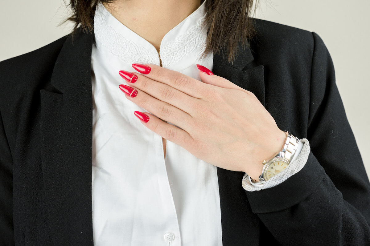 Kobieca dłoń z czerwonymi paznokciami z ozdobami